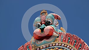 Minor demon adorns the top of colorful Hindu temple