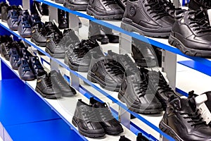 MINSK, BELARUS - MARCH 22, 2021: Black unisex autumn boots with shoelaces on retail shoes shop display shelf.