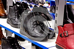 MINSK, BELARUS - MARCH 22, 2021: Black woman autumn boots with shoelaces on retail shoes shop display shelf.