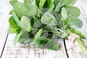 Mint. Bunch of Fresh green organic mint leaf on wooden table closeup. Selective focus.