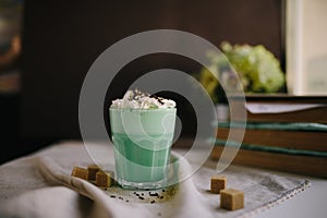Mint coffee with with cream and colorful decoration on dark background. Milk shake, cocktaill, frappuccino. Unicorn coffee, unico