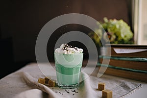 Mint coffee with with cream and colorful decoration on dark background. Milk shake, cocktaill, frappuccino. Unicorn coffee, unico