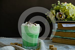 Mint coffee with with cream and colorful decoration on dark background. Milk shake, cocktaill, frappuccino. Unicorn coffee, unico