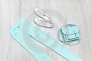 Mint green jeans and sneakers, handbag. Fashionable concept. Woo