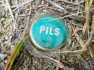 Mint green scratched beer mat in the dirt with the inscription: Pils Pilsner Bier