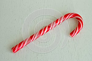 Mint hard candy cane striped in Christmas colours isolated on a white wooden surface