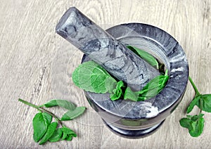 Mint in mortar and pestle. close up. cold and flu remedy.