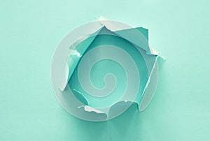 Mint pastel color background with hole in the paper. Copy space.