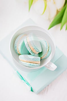 Mint or tiffany color macaron or macaroon dessert with vanilla cream in glass. Paste photo, copy space