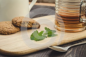 Mint on a wooden board with cookies and tea/mint on a wooden board with cookies and tea. Selective focus