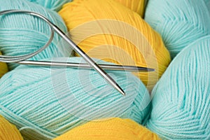 Mint and yellow acrylic yarn with knitting needles. Beautiful mint and yellow yarn for knitting baby clothes. For yarn, children`