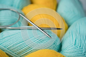 Mint and yellow acrylic yarn with knitting needles. Beautiful mint and yellow yarn for knitting baby clothes. For yarn, children`