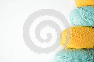 Mint and yellow acrylic yarn on a white background,with copyspace. Beautiful yarn for knitting baby clothes. For yarn, children`s