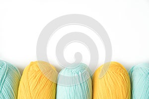 Mint and yellow acrylic yarn on a white background,with copyspace. Beautiful yarn for knitting baby clothes. For yarn, children`s