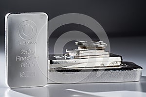 Minted silver bars and coins against a gray background