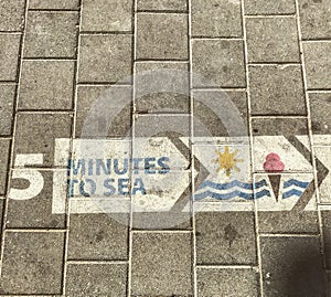 5 Minutes to the Sea - A Sidewalk in Tel Aviv Directs People to the Mediterranean photo