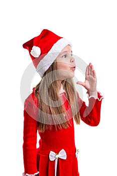 Miracle christmas girl blowing the air with raised hand, wearing a santa hat isolated over a white background