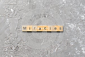 Miracles word written on wood block. miracles text on cement table for your desing, concept
