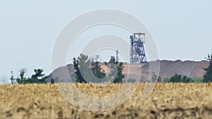 Mirage or heat waves over field, steel headframes of iron ore mines