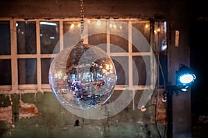 Mirror ball under the ceiling on the background of old walls and Windows.