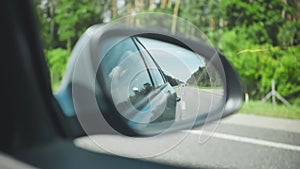 The mirror of the car while driving on the motorway.