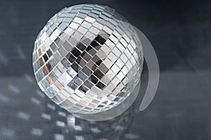 Mirror disco ball on black background. Brilliant decoration, silver decor.