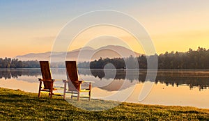 Mirror Lake two sunlit wooden Adirondack chairs sunrise Lake Placid NY