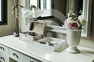 Mirror,lamp,jewelry and makeup box on a table
