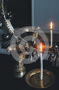 Mirror magick witchcraft - scrying with a white lit burning candle to read the flame. A reflection of skinny candle stick photo