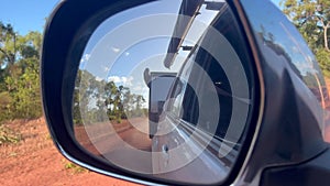 Mirror reflection of car towing an off road caravan