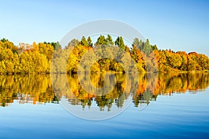 Reflection of autumn trees on lake