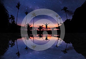 Mirror reflection of Panoramic landscape of man standing on the coconut beach with a million stars and sunrise early