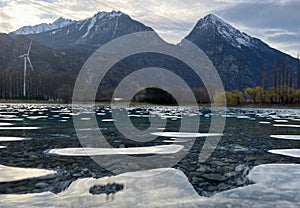 Mirror reflection of a snow-covered mountain in a lake with mountain water in Martigny, Switzerland