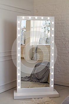 Mirror whith white frame and light bulbs in interior flat photo