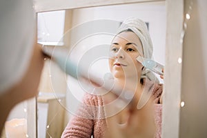 Mirrored image of a girl cleansing her pores deeply