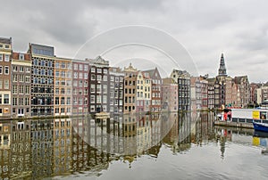 Mirroring of houses on the Damrak water surface in the centre of Amsterdam, Netherlands