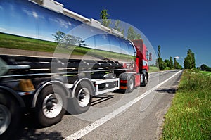 Mirroring the landscape chrome tank truck moving on a highway