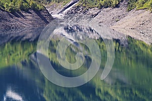 Mirroring woods in artificial Lake Grand-Maison, France