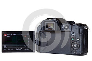 Mirrorless high-tech digital camera from rear with viewscreen out and engergised