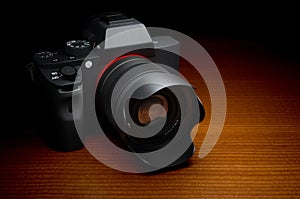 Mirrorless interchangeable-lens camera. Digital camera on wooden table, 3D rendering
