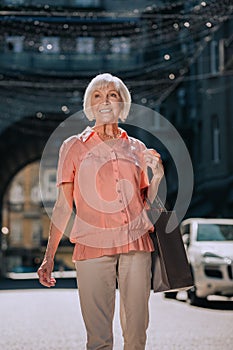 Mirthful elderly woman enjoying shopping day stock photo