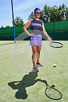 Mirthful sportswoman playing tennis on the court