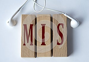 MIS - acronym on wooden blocks on white background with wired headphones