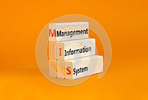 MIS management information system symbol. Concept words MIS management information system on wooden blocks on beautiful orange