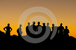 Misaligned group of people silhouettes at sunset