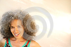 Mischievous smiling woman over 50 Curly graying hair