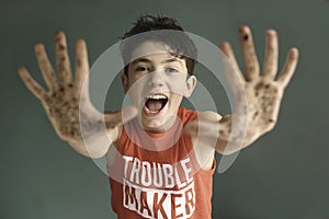 Mischievous teen boy with dirty hand smile