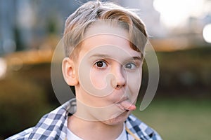 A mischievous teenager makes faces at the camera, sticks out his tongue and indulges.