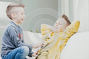 Mischievous young boy tickling his older brother