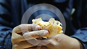 Miserable pauper eating leftover burger, man suffering from hunger and poverty